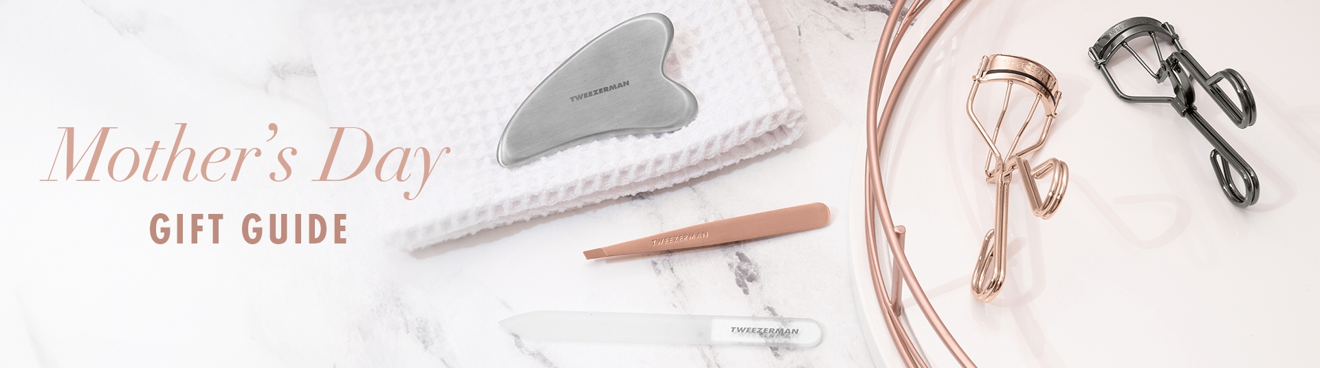 Tweezerman | Mother's Day Gift Guide. Stainless steel gua sha, rose gold slant tweezer, glass nail file, rose gold classic lash curler, procurl lash curler